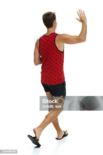 Rear View Of Man Walking Waving Hand Stock Photo - Download Image Now - Walking, White Background, Rear View