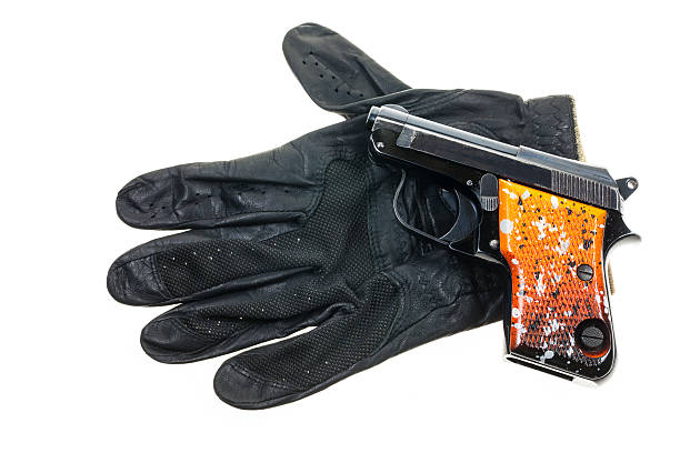 istock Gun on Leather gloves background. 529500035