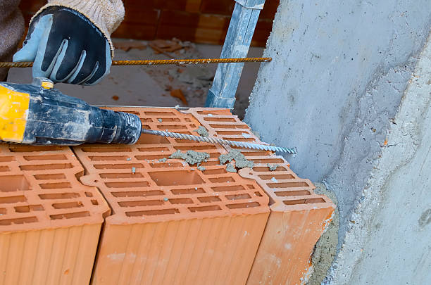 mason drills ein loch mit einem power-drill - mason brick bricklayer installing stock-fotos und bilder