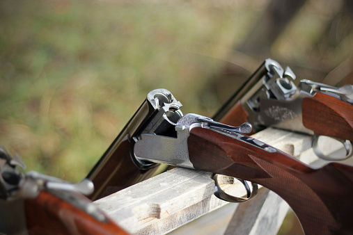 Skeet shooting, closeup of several shotguns in line