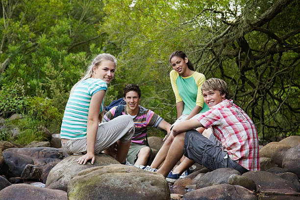 istock Young Friends Sitting by Creek 529557889