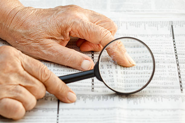 istock Senior woman reading stock listings 529559901