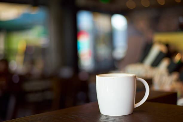 white mug stands on coffee shop counter