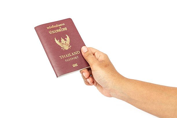 istock Hand holding Thailand passport isolated on white background 529573559