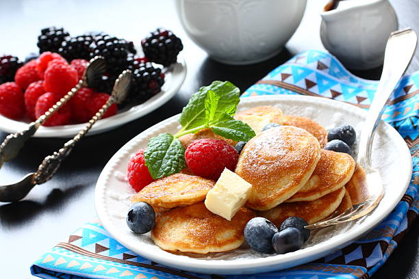 olandese chiamato poffertjes mini frittelle con frutti di bosco - repast foto e immagini stock