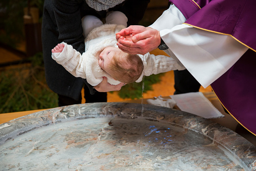 Sacerdote es baptizing little baby girl in a la iglesia photo