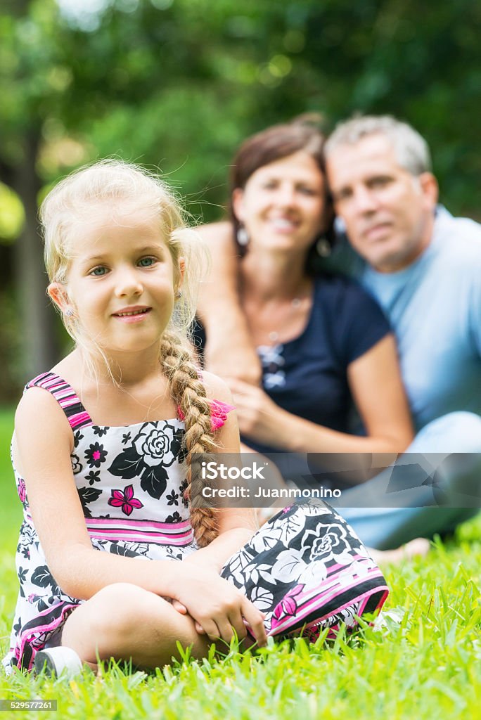 Family together Mature couple posing with their daughter sitting in a park 40-49 Years Stock Photo