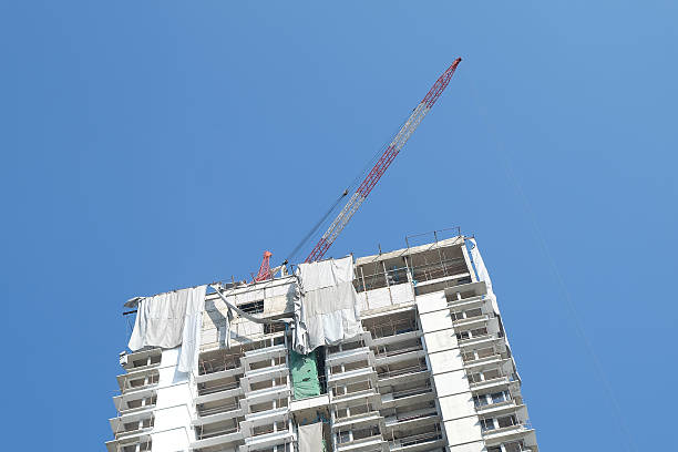 gru e costruzione di edifici centro contro il cielo blu - formwork concrete curb cement foto e immagini stock