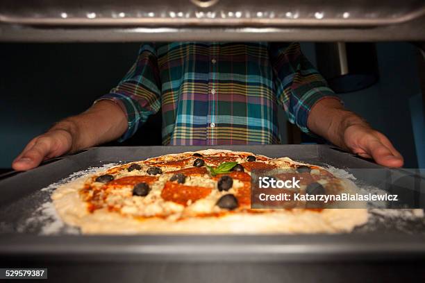 Man Putting Pizza Into Oven Stock Photo - Download Image Now - Adult, Baking, Chef