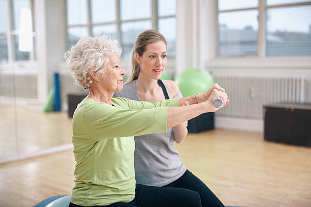 starsza kobieta szkolenia w siłowni z osobisty trener - pilates health club gym exercising zdjęcia i obrazy z banku zdjęć