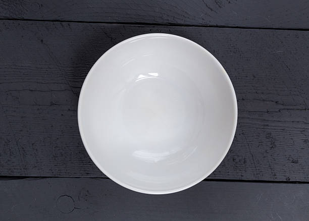 istock Empty bowl on a black wooden bird's eye view 529580263