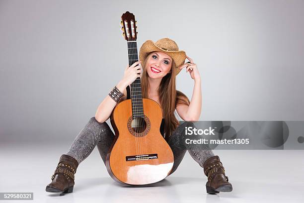 The Beautiful Girl In A Cowboys Hat And Acoustic Stock Photo - Download Image Now - Acoustic Guitar, Acoustic Music, Adult