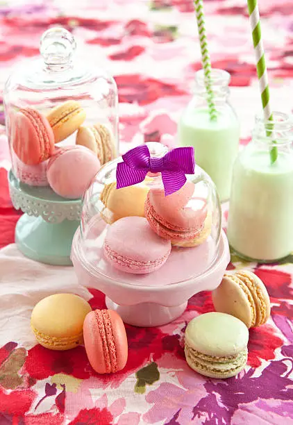 Colorful french macaroons on bright  floral tablecloth
