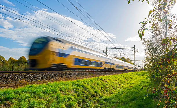 Passenger train moving at high speed in sunlight stock photo