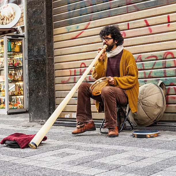 Brazilian street musician in turkey plays caribbean drum and didgeridoo