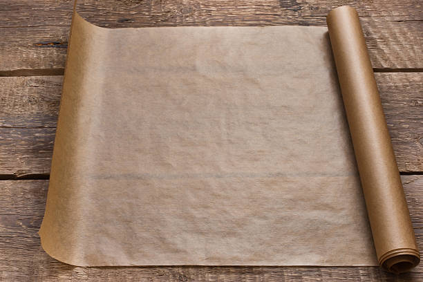 istock Open roll of paper on the wooden table background 529598049