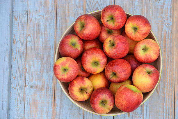 istock apples in a green fruit bowl on wooden background 529603023