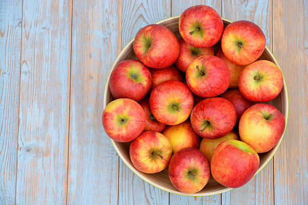 istock apples in a green fruit bowl on wooden background 529603231