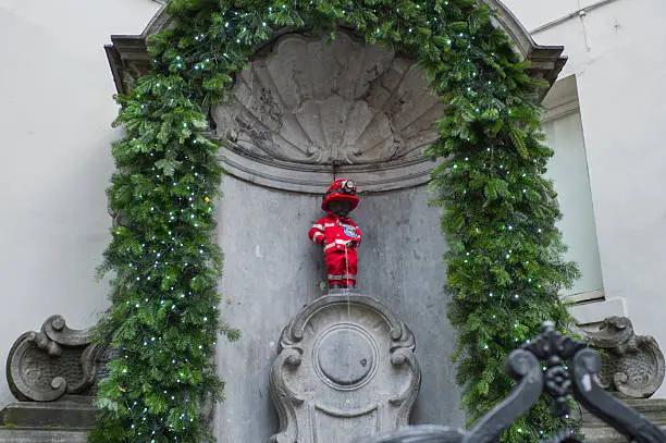 manneken pis sculpture with christmas fireman decoration in brussel belgium