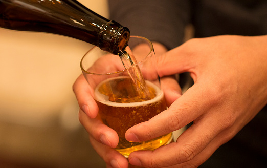 A man politely receiving beer in his glass.