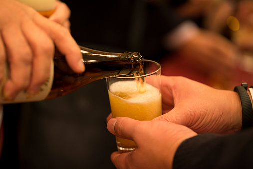 A man politely receiving beer in his glass.