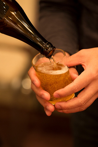 A Japanese businessman politely receiving beer in his glass.