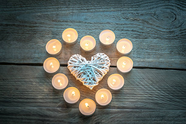 istock Heart with burning candles on the wooden background 529653253