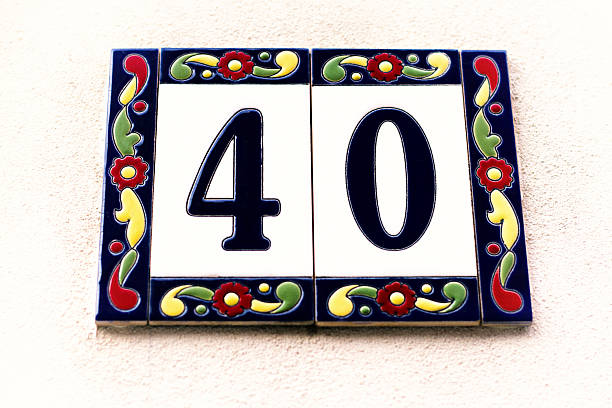Number 40 street address tiles on white wall. Shot in Italy.