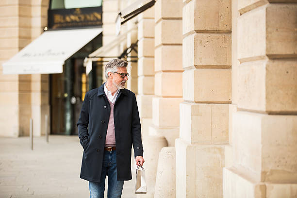 Middle aged man window shopping in Paris center.