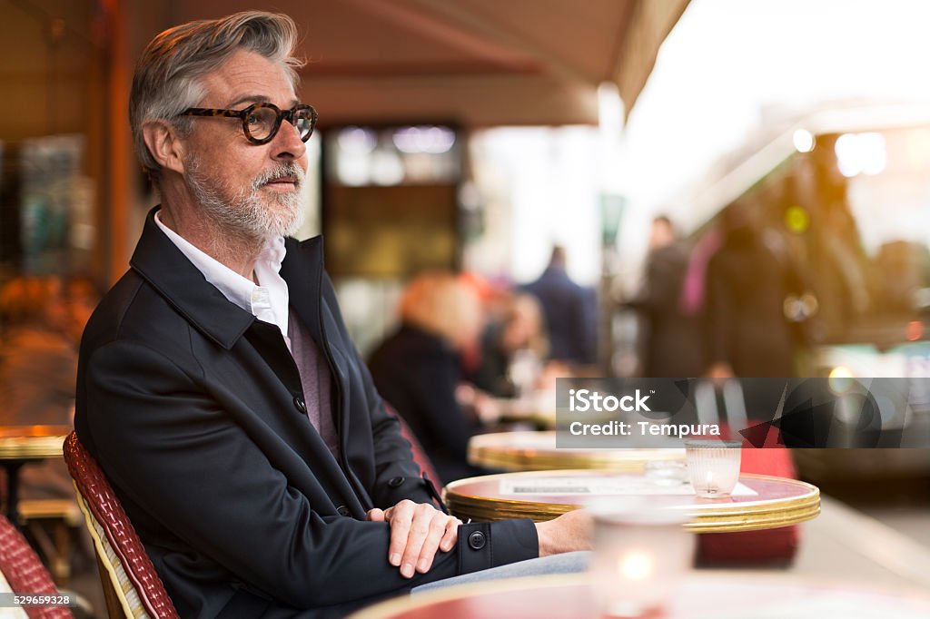 Middle aged man sitting in a french terrace. Sitting in a french terrace on a nice afternoon Cafe Stock Photo