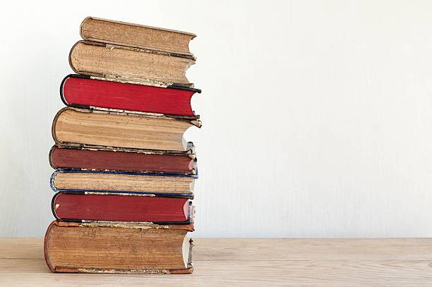 istock Stack of old books lying on wooden shelf 529660242