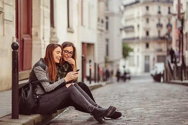 Photo of Girls in the city texting on smartphone