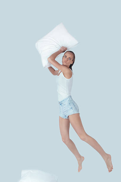 istock Girl jumping with pillow 529661266