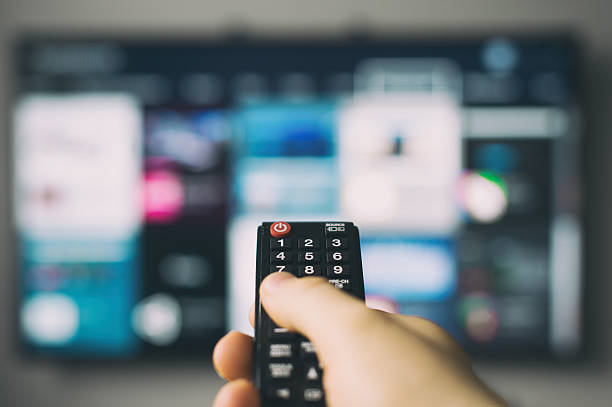 istock Male hand holding TV remote control. 529662280