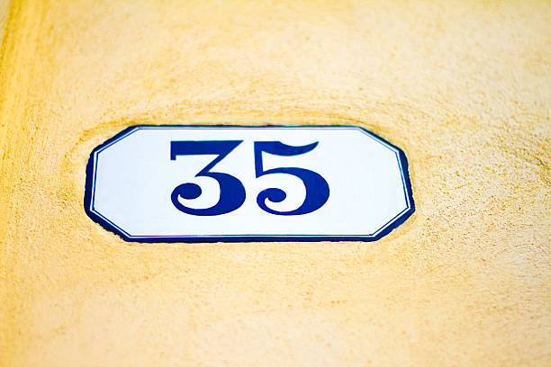 istock Number 35 Blue and White Address Tile, Yellow Wall (Close-Up) 529664466