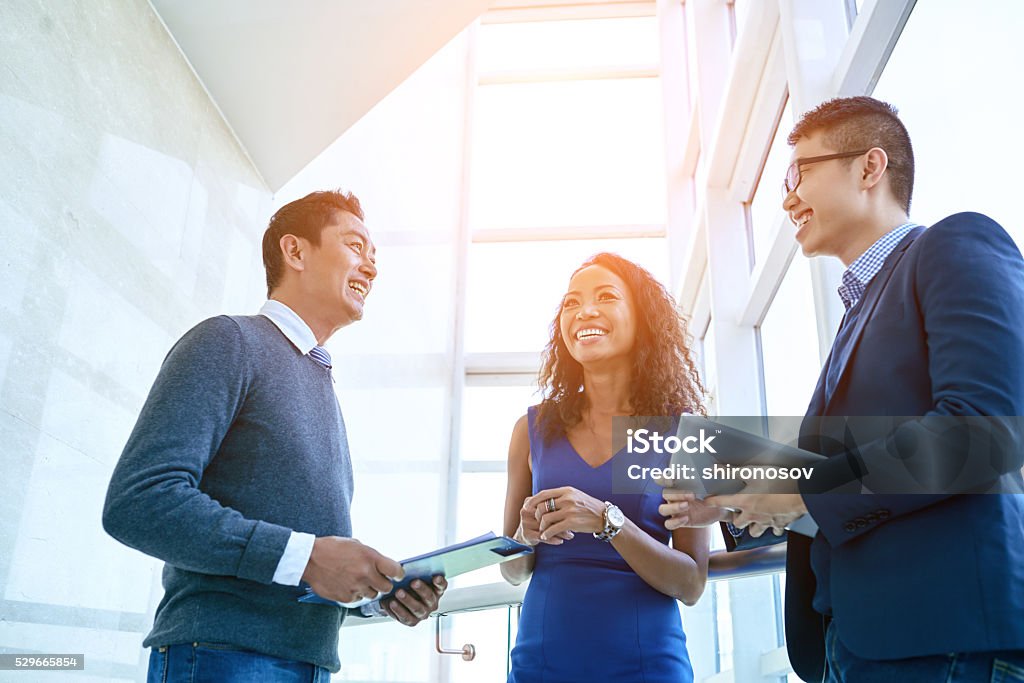 Cheerful coworkers Joking and laughing business colleagues standing in office Business Person Stock Photo