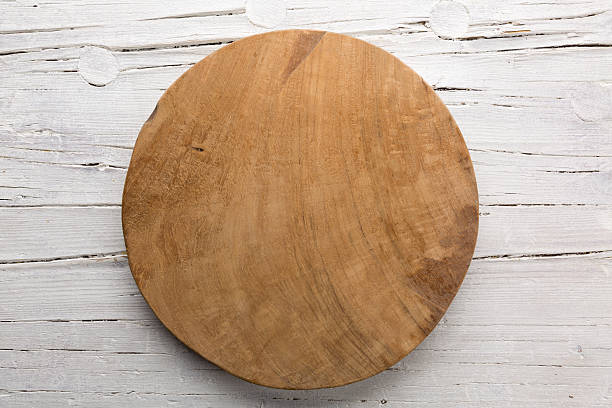 Wooden plate on white wooden background.