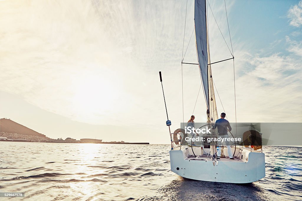 Taking an adventurous boat cruise Shot of a couple out sailing on a yacht Luxury Stock Photo