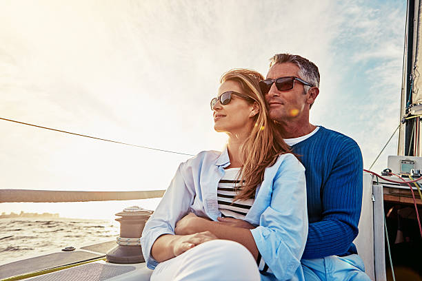 Wherever you go, go with all your heart Shot of a couple enjoying a boat cruise out on the ocean sailing couple stock pictures, royalty-free photos & images