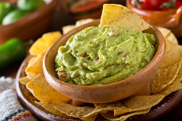 Guacamole Dip A delicious authentic mexican guacamole dip with avocado, lime, and tomato. mexican food stock pictures, royalty-free photos & images