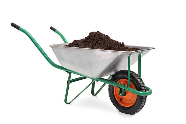 Studio shot of a wheelbarrow full of dirt Studio shot of a wheelbarrow full of dirt isolated on white background wheelbarrow stock pictures, royalty-free photos & images