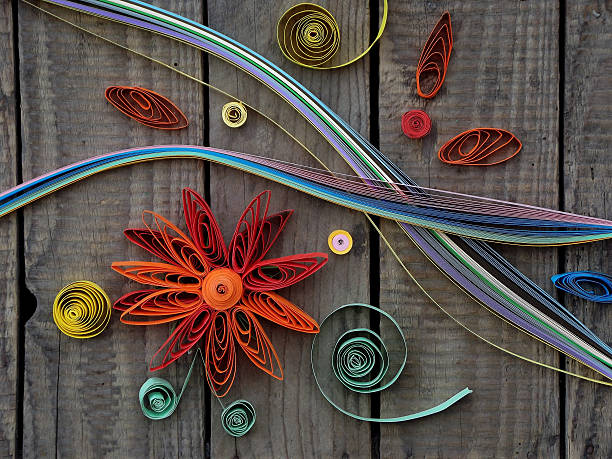 colorful paper quilling Paper quilling, colorful paper flowers on a wooden background paper quilling stock pictures, royalty-free photos & images
