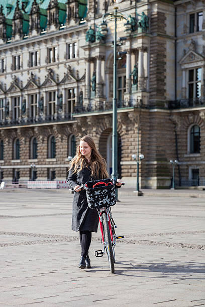 istock Woman in the city streets walking with bicycle afterwork 529673896