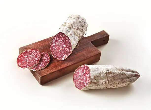 Two pieces of Salami and slices on Cutting board