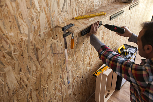 Tools For Rack Installations Man Installing A Tool Rack To A Wall Using Cordless Drill Stock Photo ...