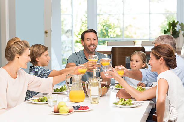 brindis familia de generación - los niños y los padres brindis bebidas mientras almuerza fotografías e imágenes de stock
