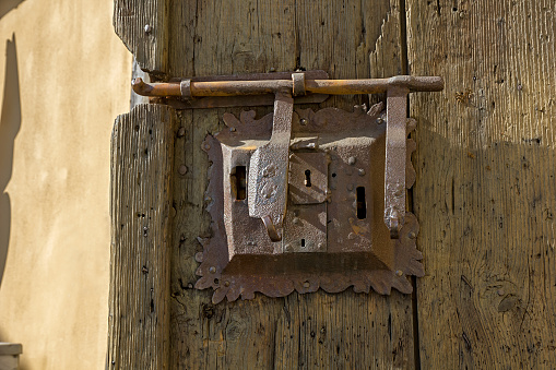 Ancient lock with latch on aged boarded door.