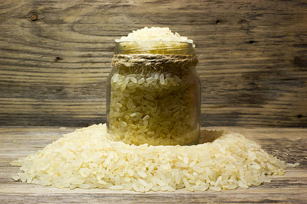 istock Rice grains in glass jar on wooden background 529681250
