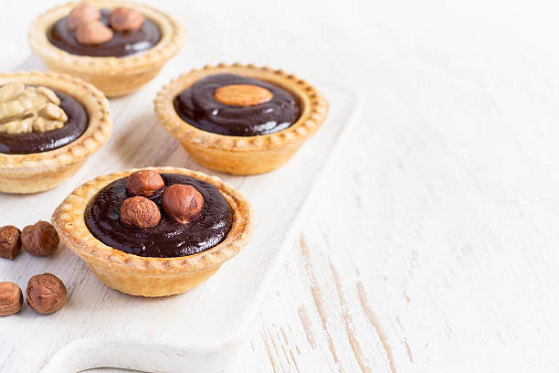 istock Nutty chocolate dessert small tarts  on a white background, spac 529681502