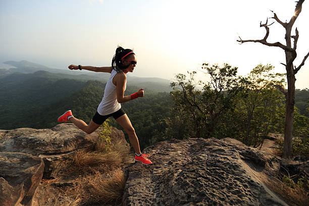 istock young asian woman runner running on mountain peak 529682322